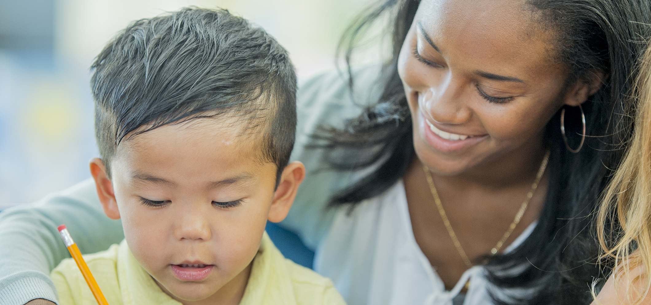 A female teacher educating an elementary grade school student.